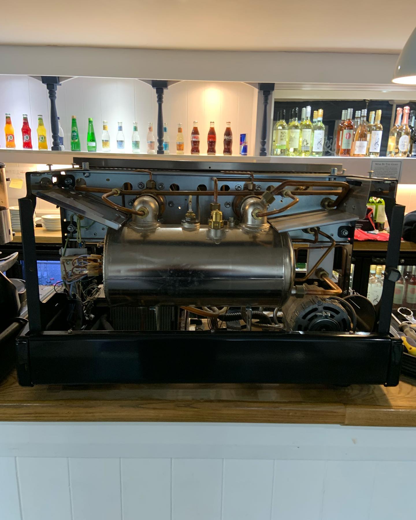 Professional coffee machine technician diagnosing espresso machine problems during service appointment